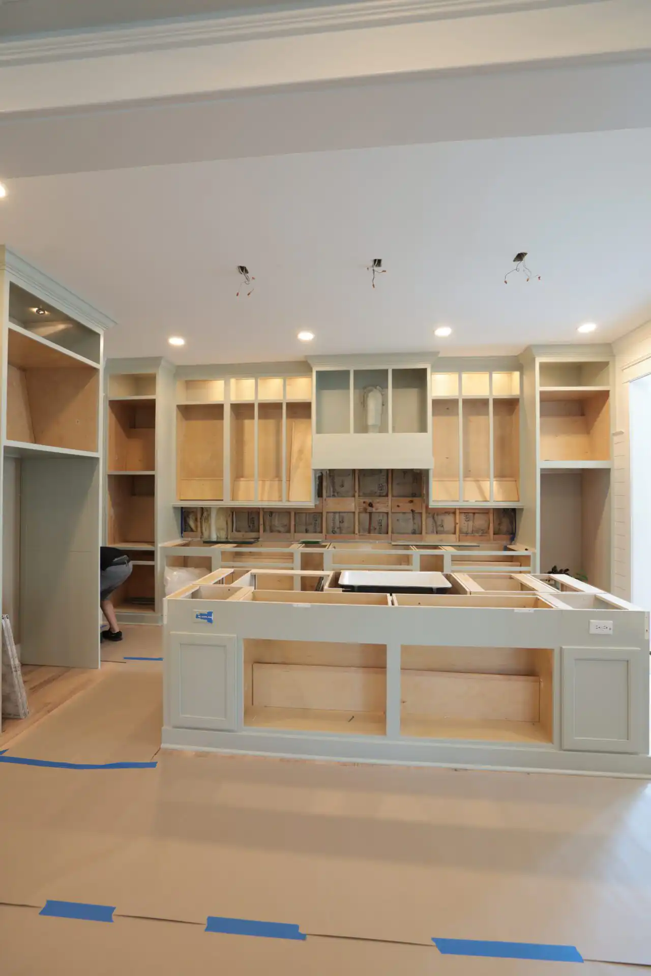 Granite Countertop Thickness: How to Choose Between 2 cm and 3 cm Painted island base cabinets with an apron-front sink set in place and open tops, waiting for the stone countertop, in the Sage Kitchen project